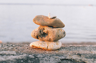 a picture of 3 stones piled in a beach
